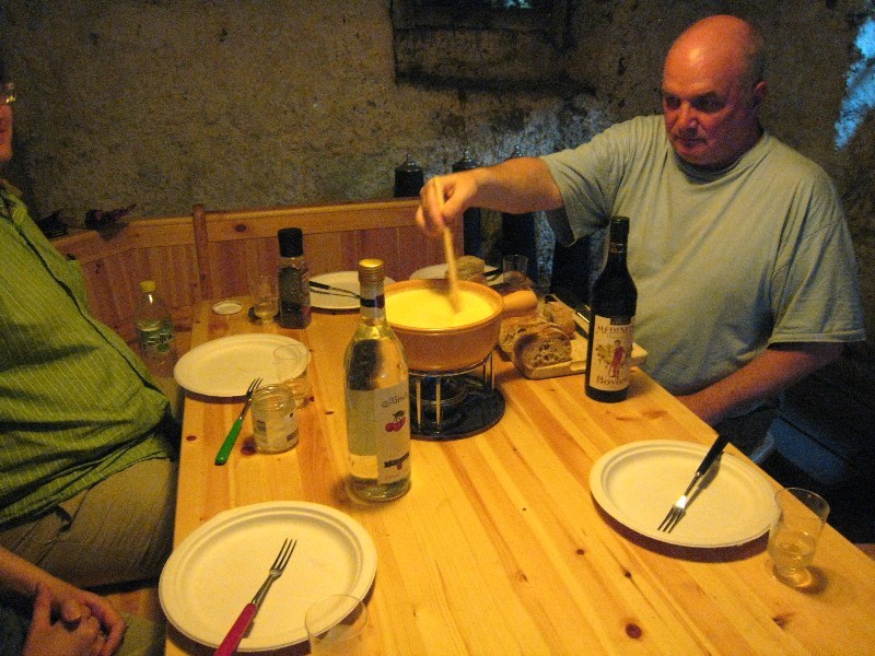 Table dans un carnotzet avec fondue sur réchaud à alcool