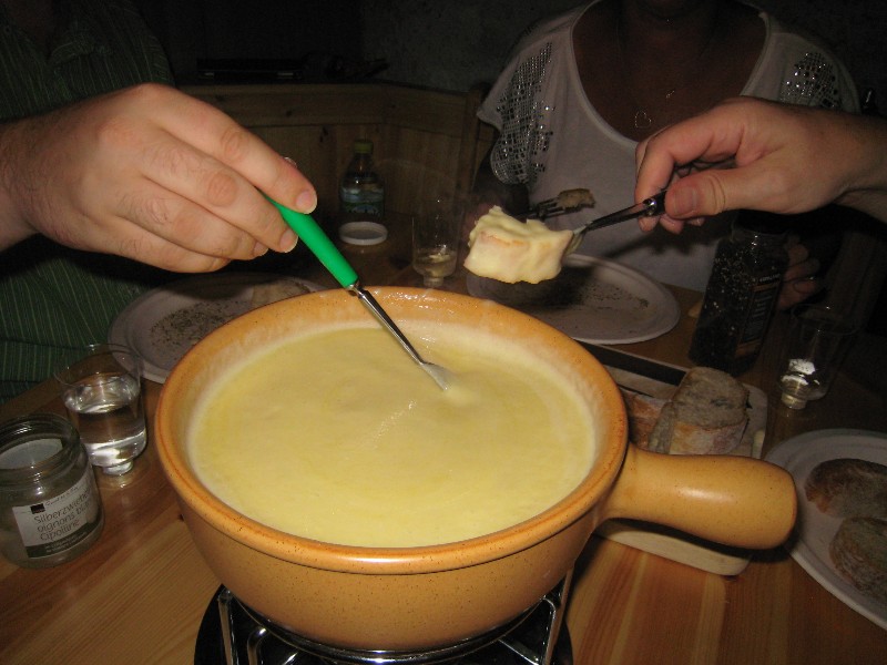 everyone stirs the fondue a bit with his fork
